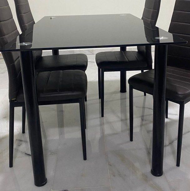 Black glass dining table with 4 black upholstered chairs