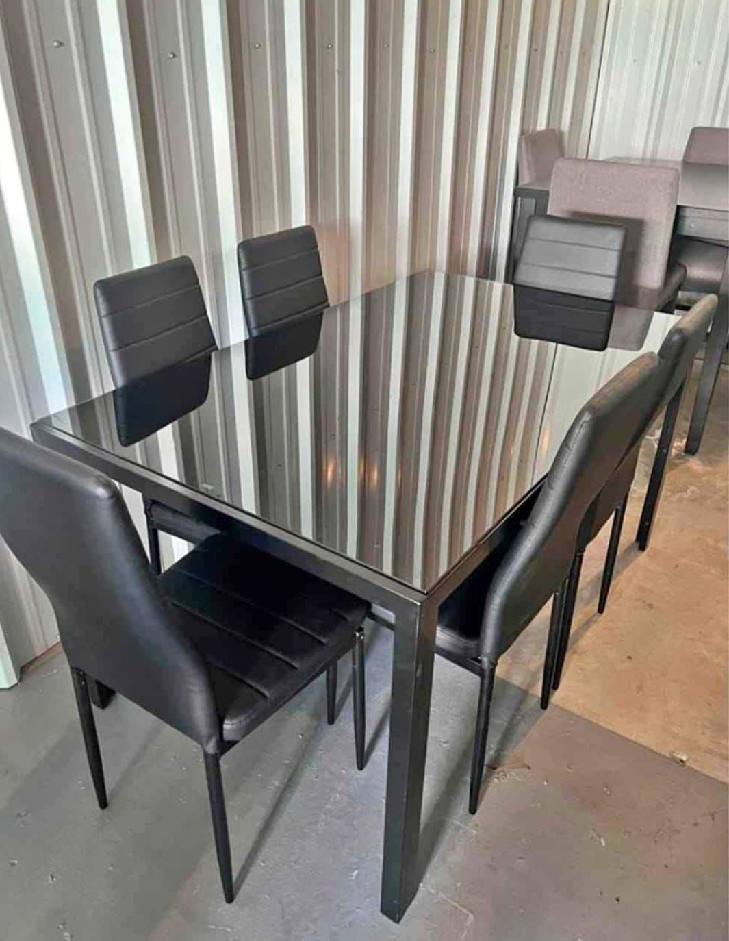 Black glass dining table with 4 black chairs