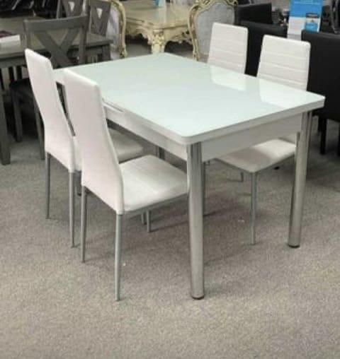 White glass-top dining table with 4 white chairs