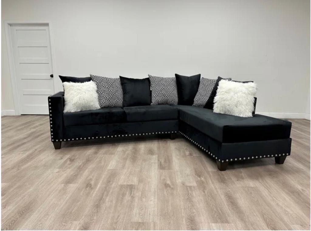Black velvet sectional sofa with accent pillows