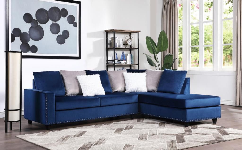 Navy velvet sectional with nailhead trim in styled living room