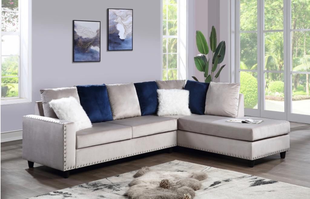 Taupe sectional with navy accent pillows in styled living room